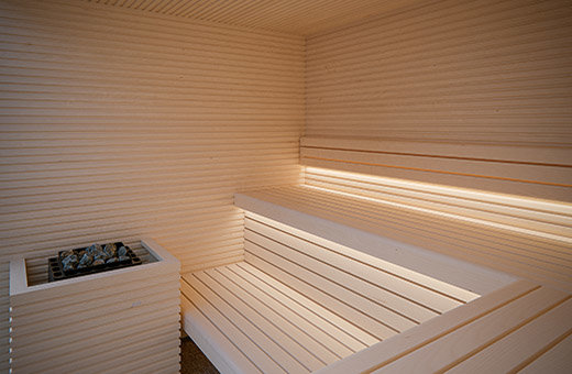Helle moderne Sauna für Zuhause, Sauna Bausatz zum Selbstaufbau. Saunaholz: moderne, geradlinige Espe. Innensauna mit indirekter LED Beleuchtung und Glasfront.